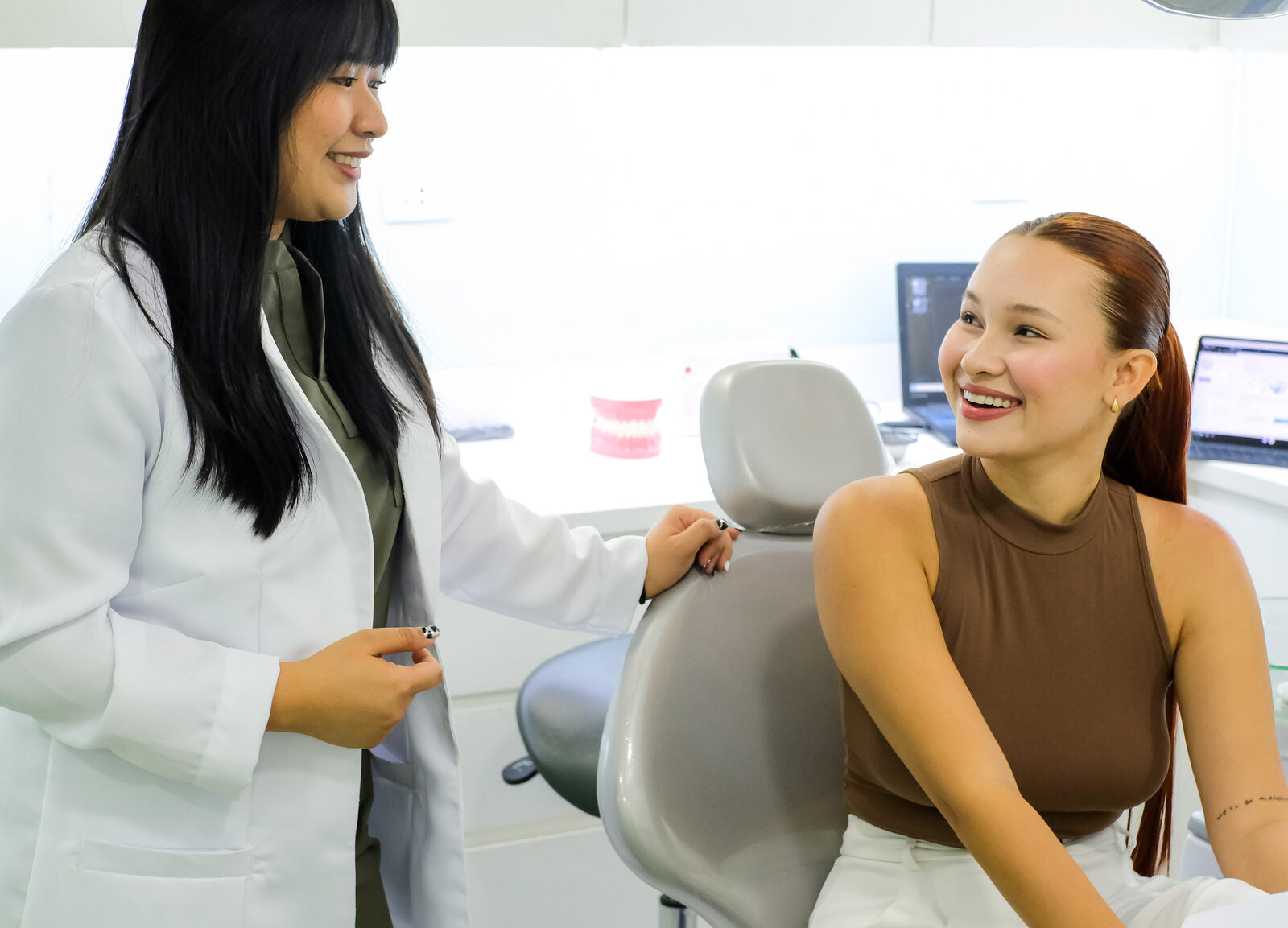 A Modern Smiles dentist chatting with a smiling patient in the treatment chair