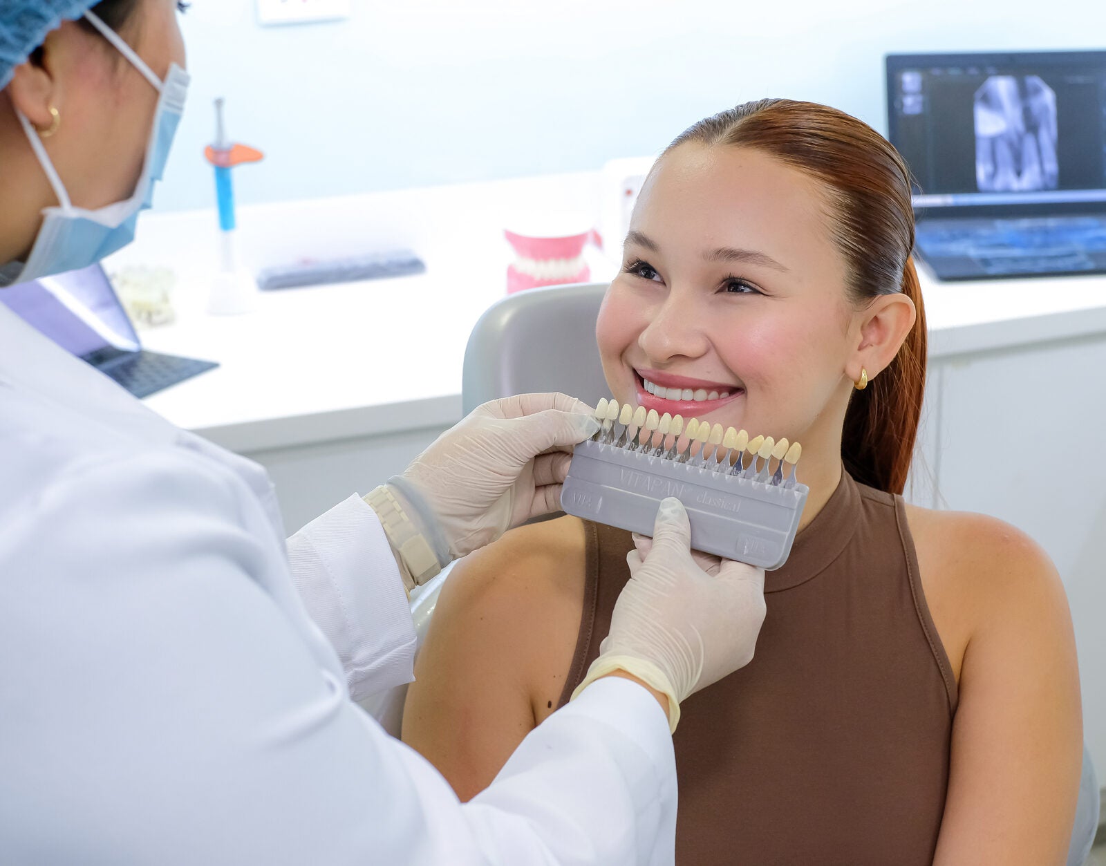 Dentist matching a patient's tooth shade at Modern Smiles